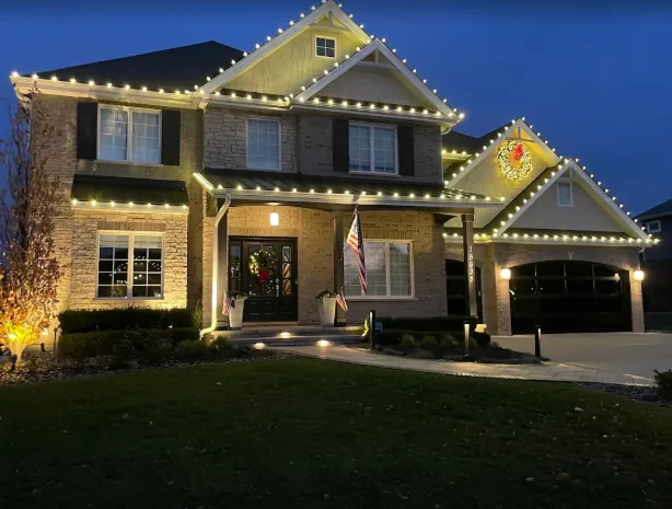 Large home with warm white lights outlining every gable peak